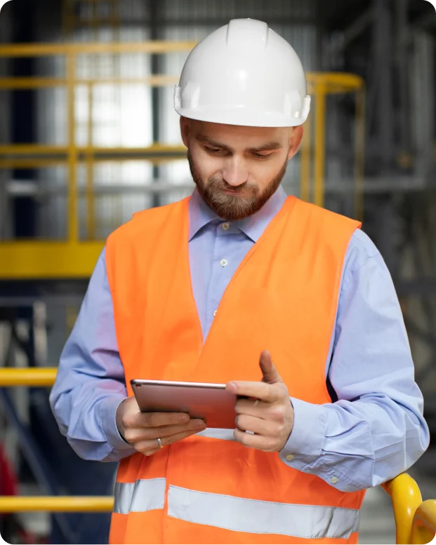 Maintenance technician using MPulse CMMS software on a tablet in an industrial facility